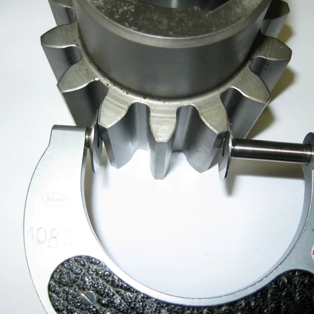 A machined gear measured across its teeth with a micrometer