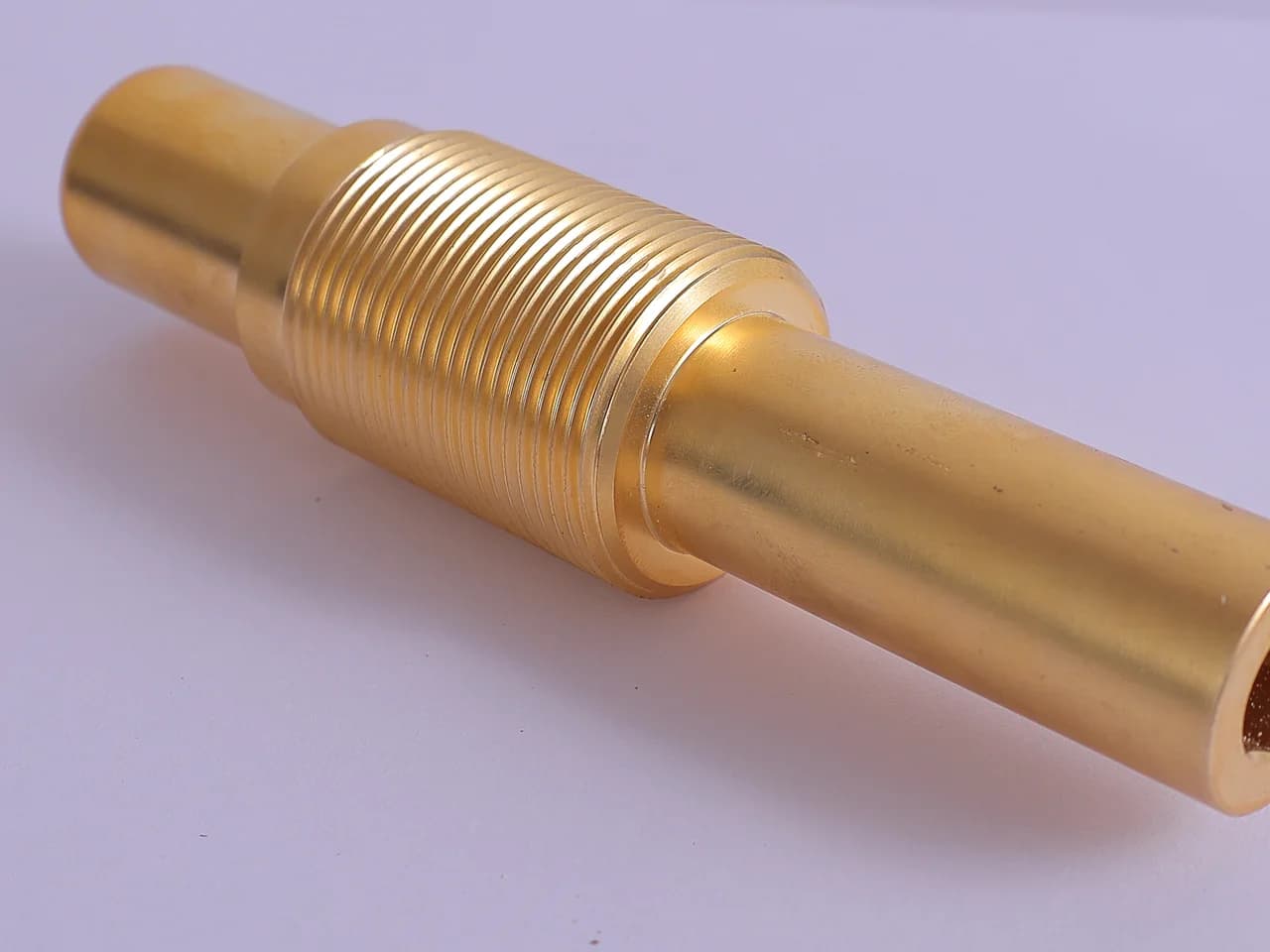 Brass precision turned spindle with a fine-pitch threaded section and hex socket